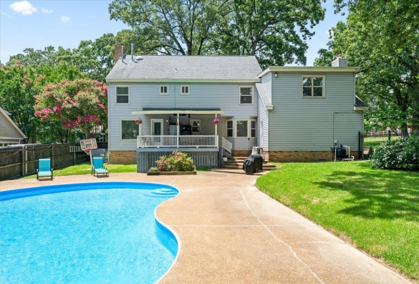 Back of house featuring a chimney, a deck, and a patio