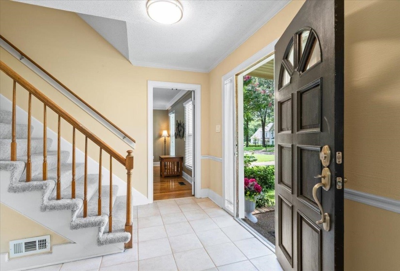 Entryway featuring ornamental molding, light tile patterned floors, and stairs