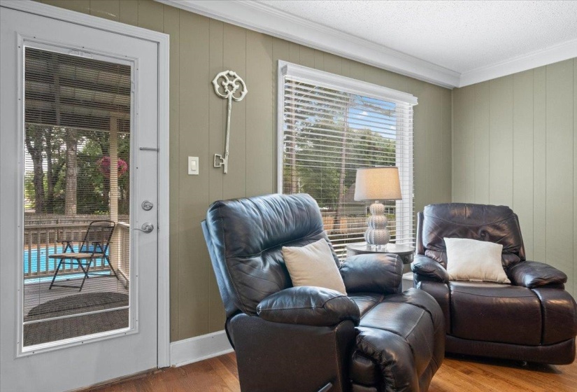 Living area featuring ornamental molding, wood finished floors, plenty of natural light, and wooden walls