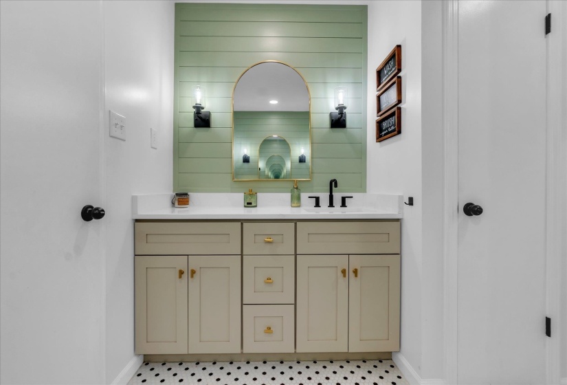 Full bathroom featuring double vanity and baseboards