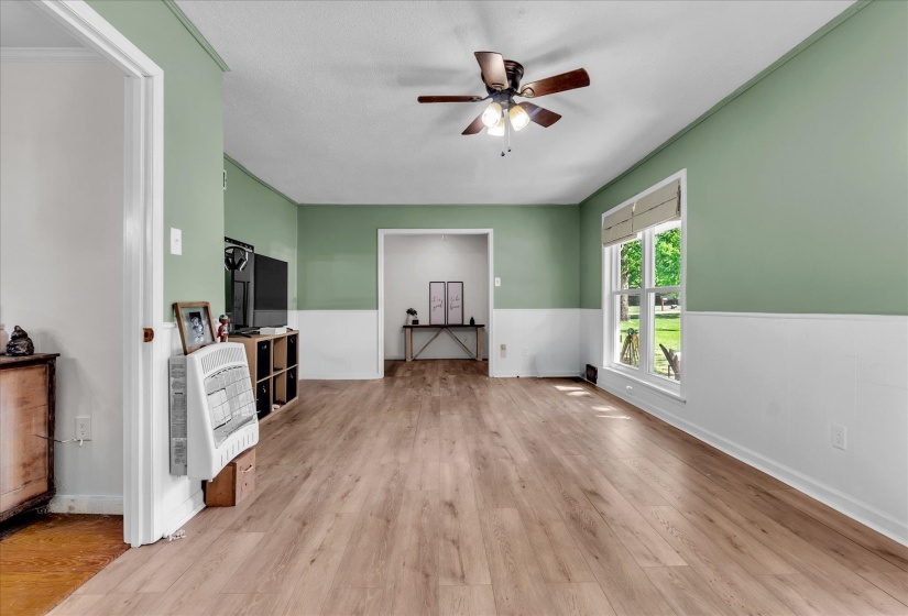 Living area featuring heating unit, light wood-style flooring, and a ceiling fan