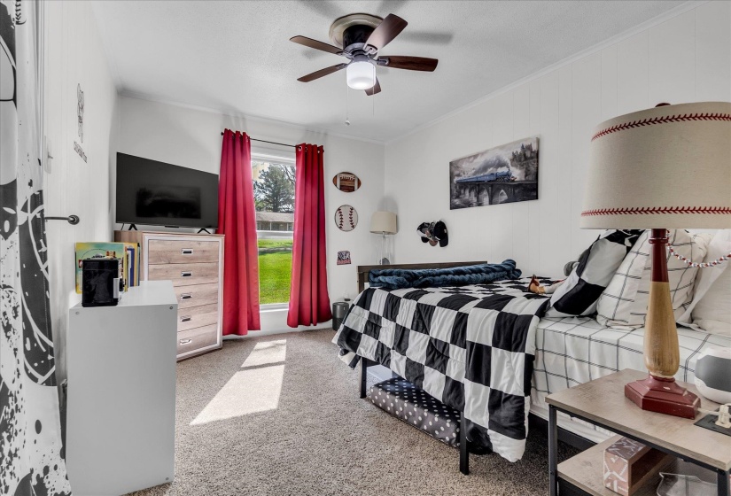 Bedroom featuring a ceiling fan, light carpet, and ornamental molding