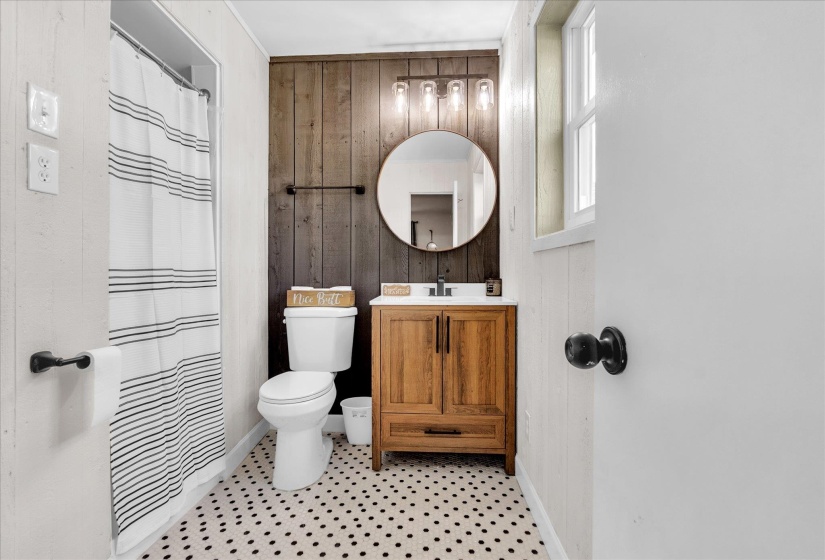 Bathroom featuring wood walls, vanity, and curtained shower