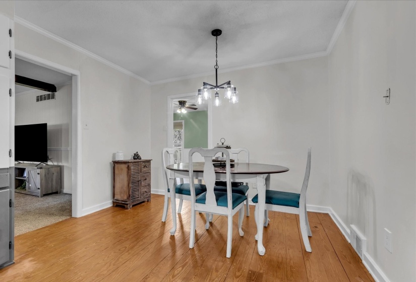 Dining room featuring crown molding, light wood-style flooring, and ceiling fan