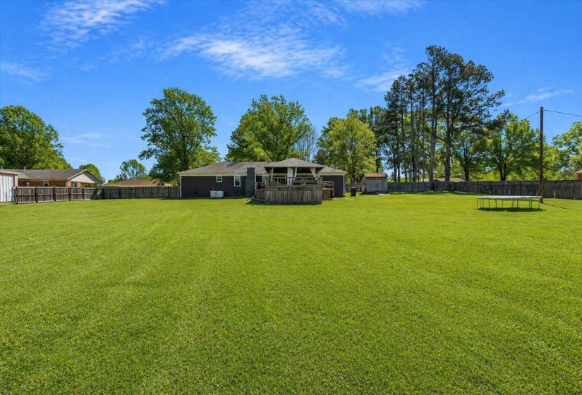 Expansive green lawn with a wood privacy fence