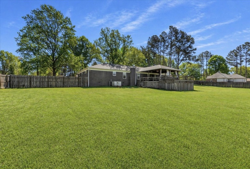 Expansive green lawn with a privacy fence