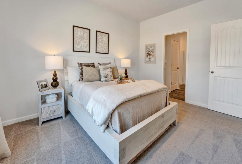 Bedroom with light colored carpet and baseboards