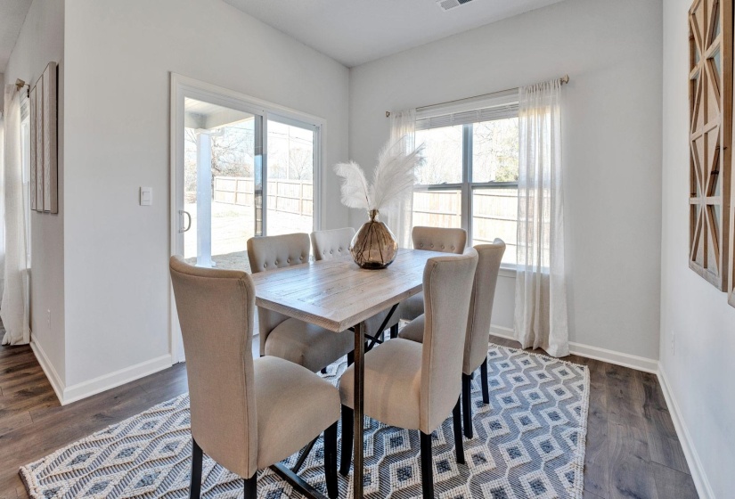 Dining area with dark wood-type flooring and baseboards