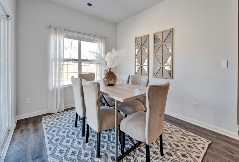 Dining area with dark wood-type flooring and baseboards