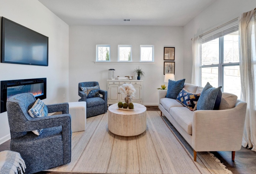 Living room featuring a glass covered fireplace and wood finished floors