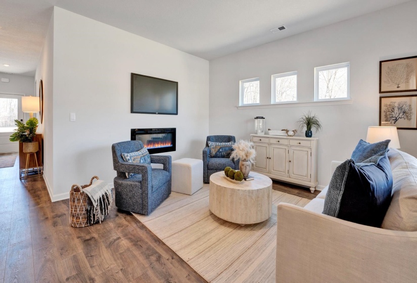 Living area featuring light wood-style flooring and a glass covered fireplace