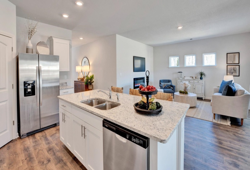 Kitchen featuring open floor plan, white cabinets, stainless steel appliances, light stone countertops, and dark wood-style flooring