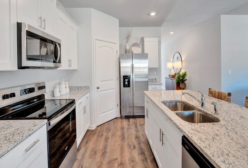 Kitchen featuring stainless steel appliances, white cabinetry, light wood-style flooring, and recessed lighting