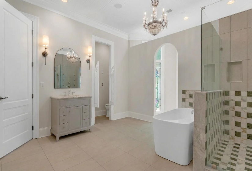 Full bath featuring suspended lighting, a walk in shower, light tile patterned floors, vanity, and crown molding
