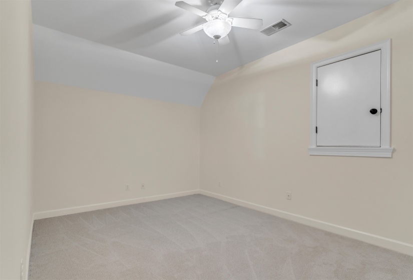 Spare room with vaulted ceiling, light carpet, and ceiling fan