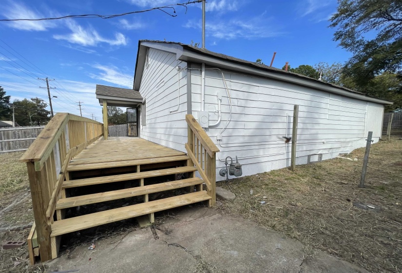 View of side of home featuring a wooden deck