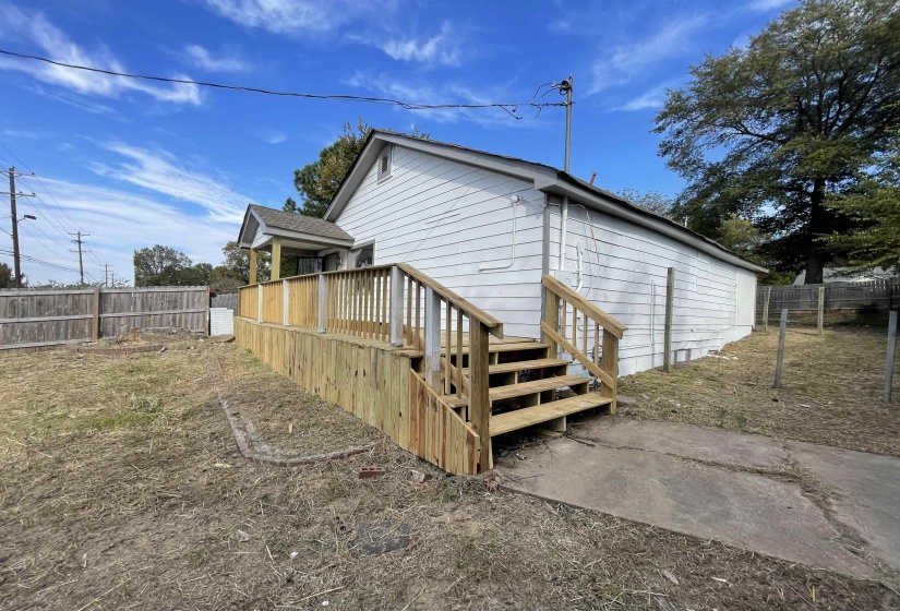 View of side of home with a wooden deck