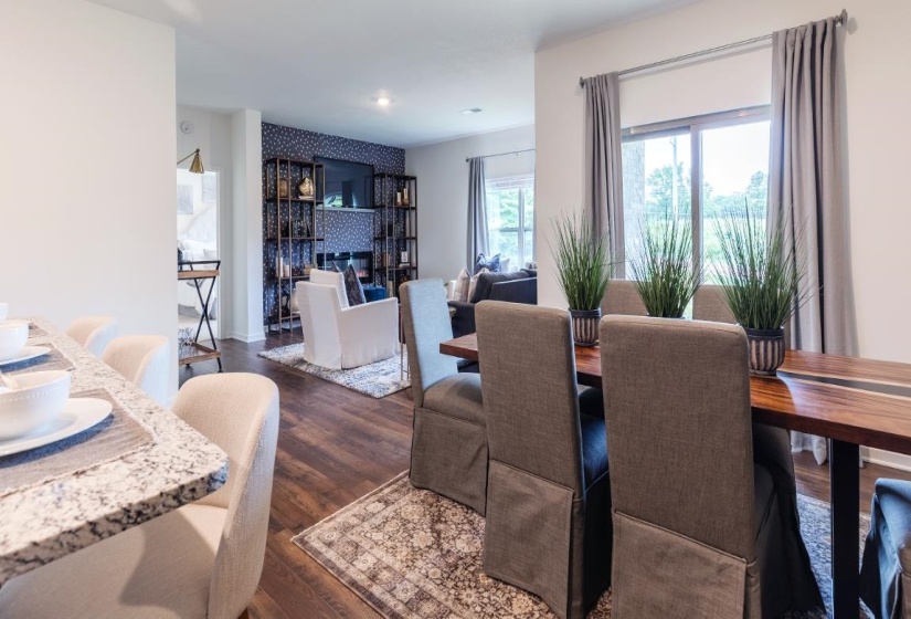Dining room featuring dark wood-style floors and a large fireplace