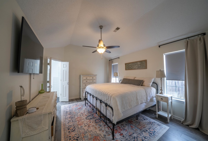 Bedroom with a ceiling fan, wood finished floors, and lofted ceiling
