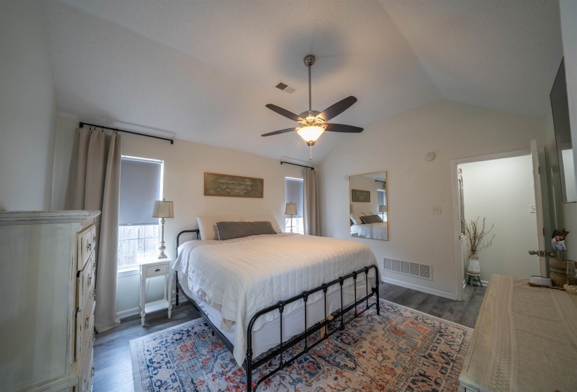 Bedroom featuring lofted ceiling, a ceiling fan, and dark wood-type flooring