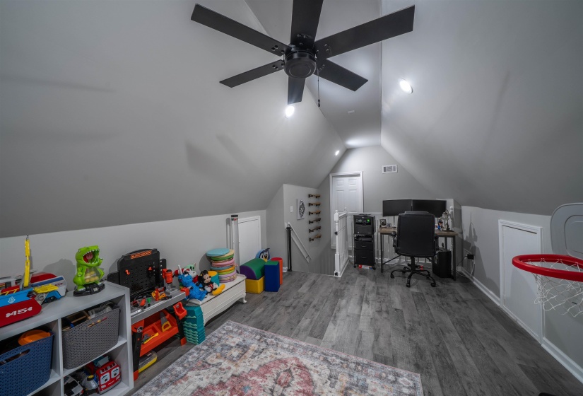 Home office with vaulted ceiling and wood finished floors