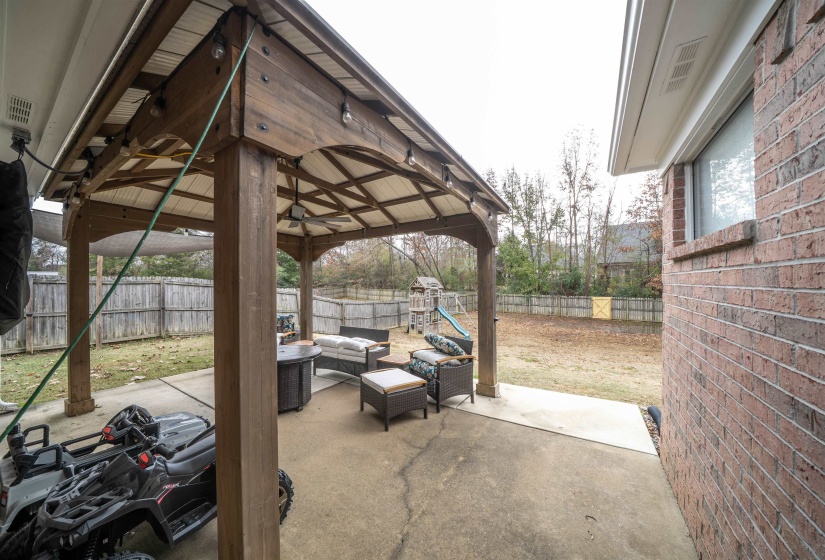 Fenced backyard with a gazebo, an outdoor living space, and a patio area