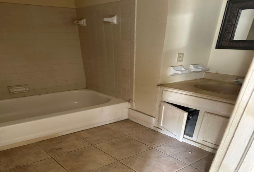 Bathroom with vanity, light tile patterned flooring, and shower / tub combination