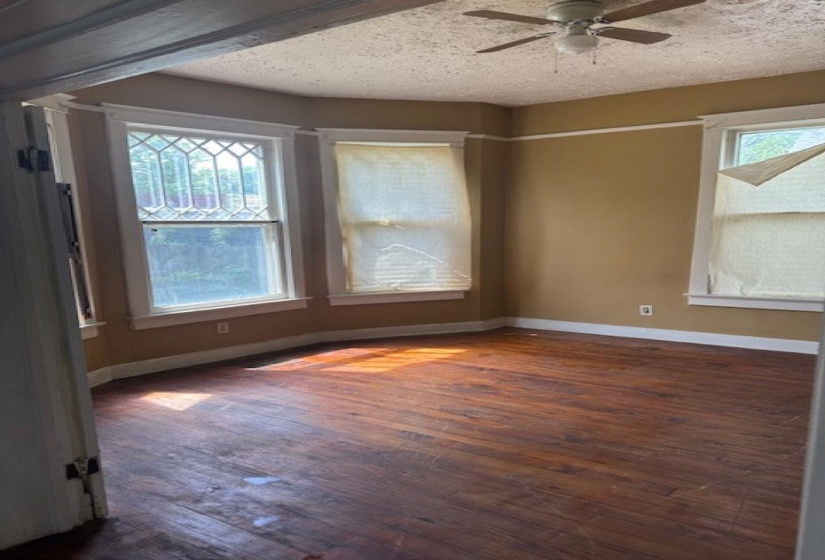 Unfurnished room featuring dark wood-style floors, a ceiling fan, and a textured ceiling