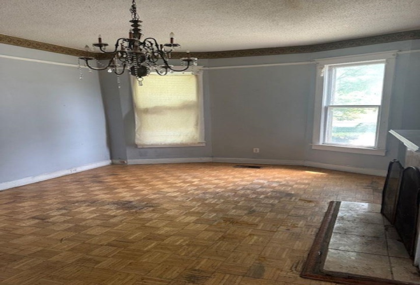 Unfurnished dining area with a textured ceiling, parquet flooring, and a chandelier