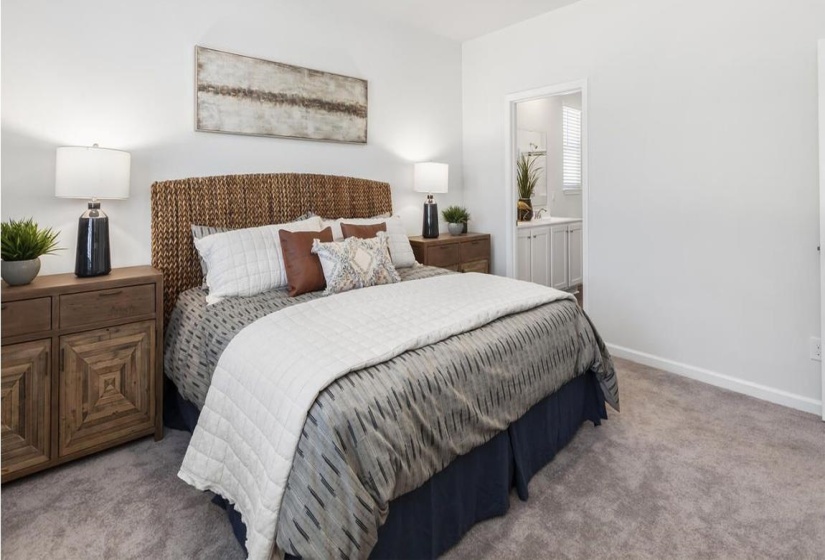 Carpeted bedroom featuring baseboards and ensuite bath