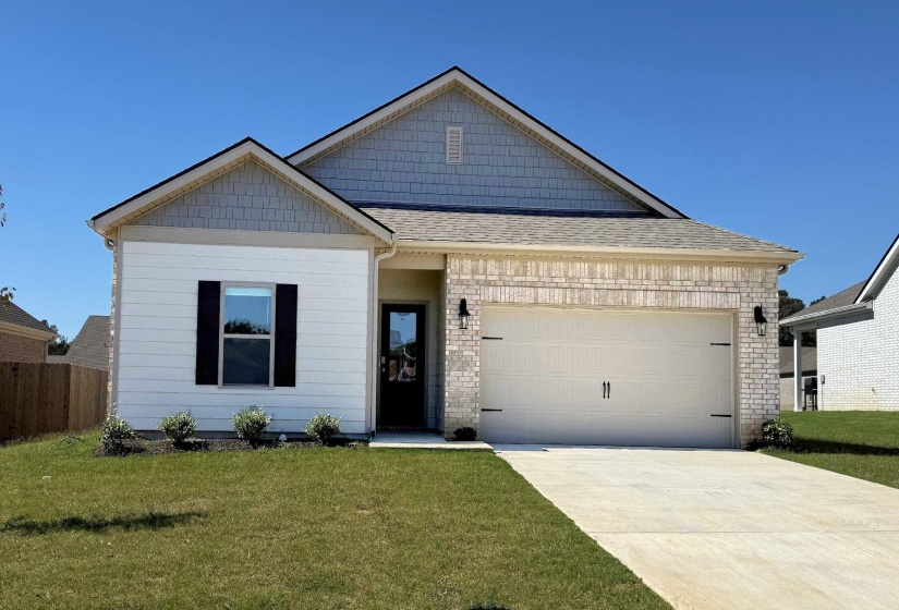 View of front facade featuring a garage, fence, a front yard, and concrete driveway