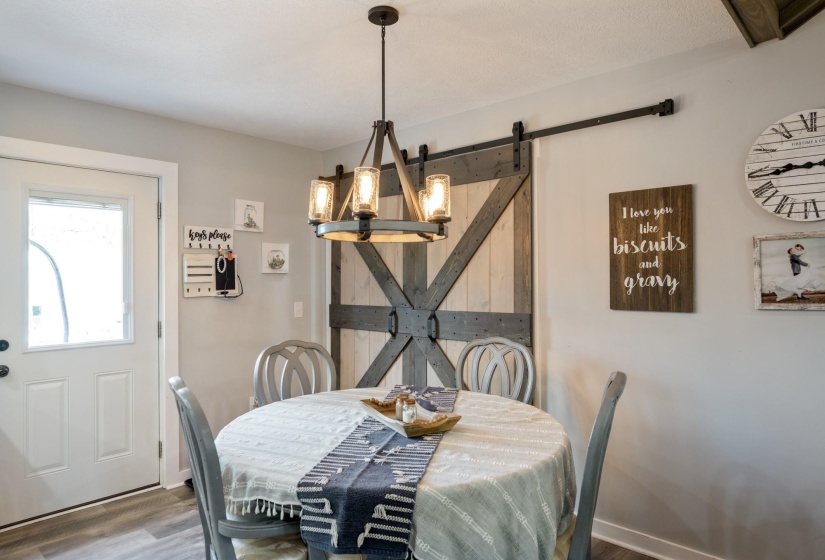 Dining area with a barn door and wood finished floors