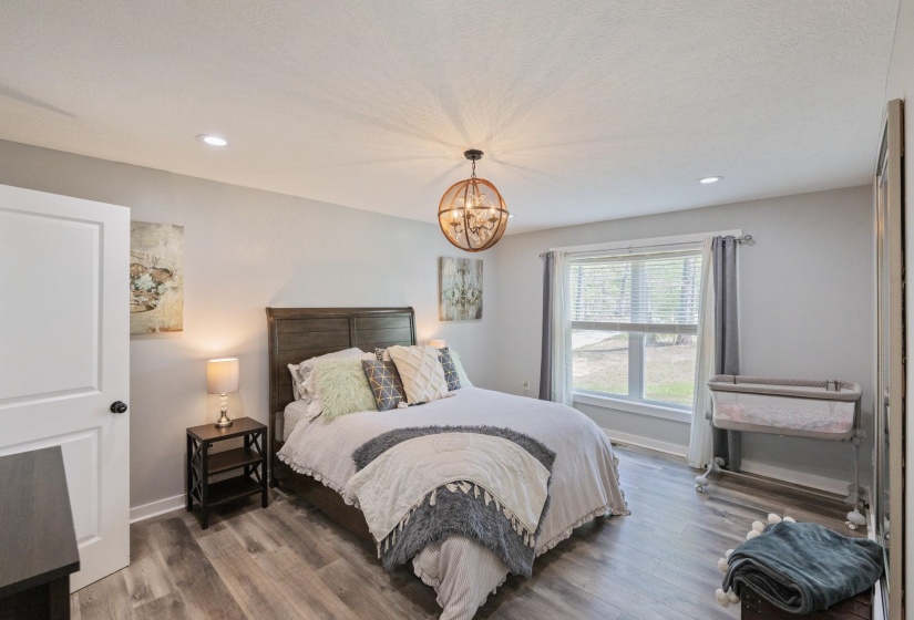 Bedroom featuring wood finished floors and hanging lights