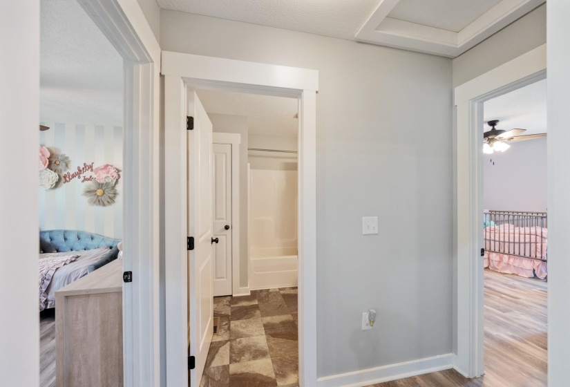 Corridor featuring baseboards and attic access