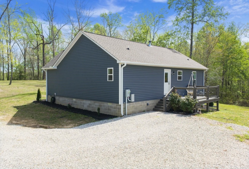 View of property exterior with a shingled roof, a yard, a deck, and crawl space