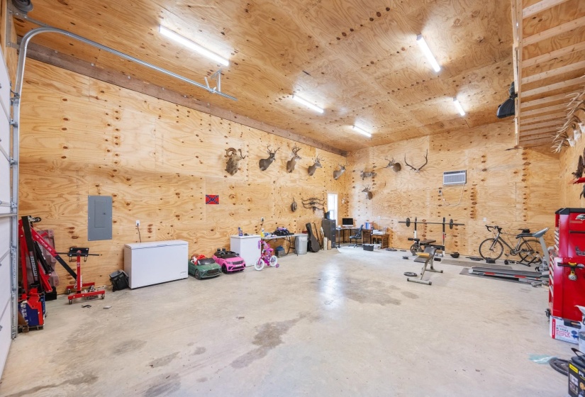 Garage with electric panel and wooden walls