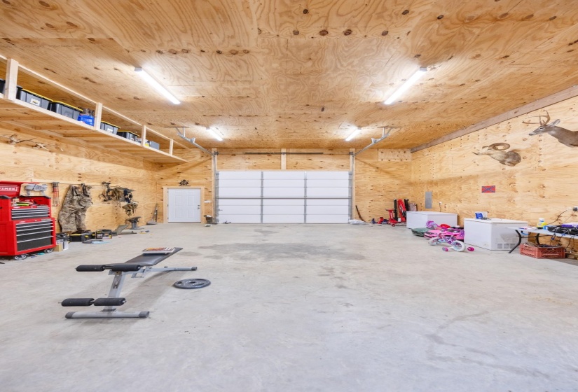 Garage featuring white refrigerator and wood walls