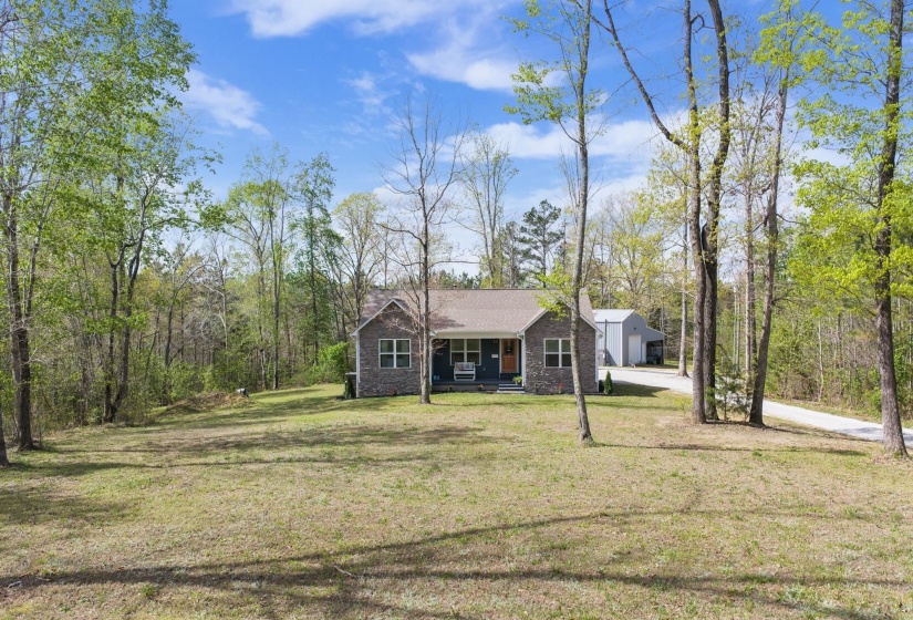 View of front of property featuring covered porch, a front lawn, and driveway