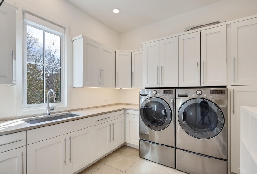 Laundry room featuring washing machine and clothes dryer, cabinet space, light tile patterned flooring, and recessed lighting