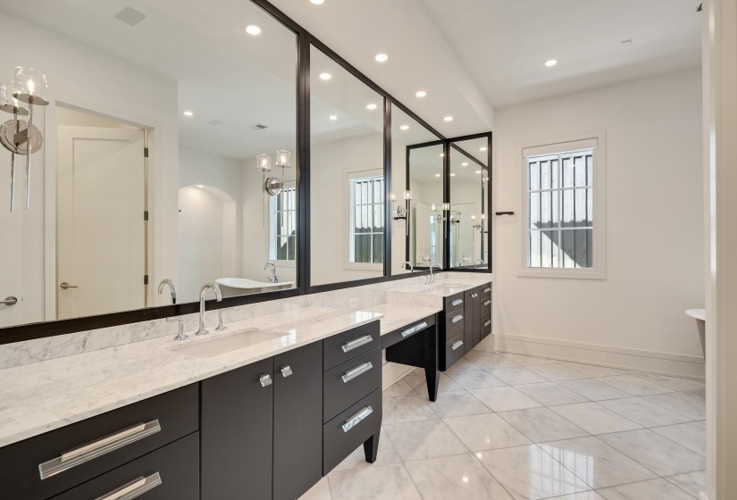 Bathroom featuring vanity, a freestanding tub, plenty of natural light, and recessed lighting
