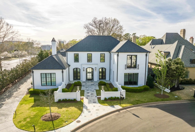 French provincial home with stucco siding, a fenced front yard, and a chimney
