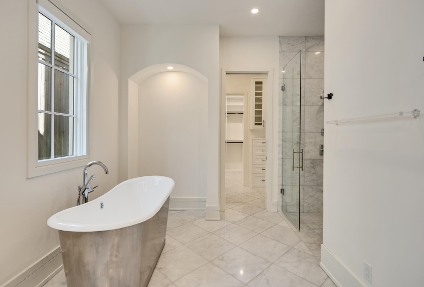 Bathroom featuring a walk in closet, a soaking tub, a stall shower, and recessed lighting