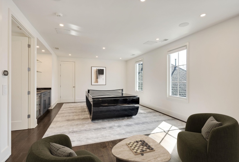 Living area with recessed lighting and dark wood-style floors