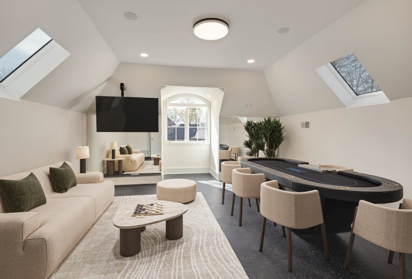 Rec room featuring a skylight, lofted ceiling, and recessed lighting