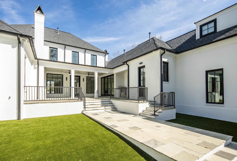 Rear view of property featuring a yard, stucco siding, a patio area, a chimney, and ceiling fan