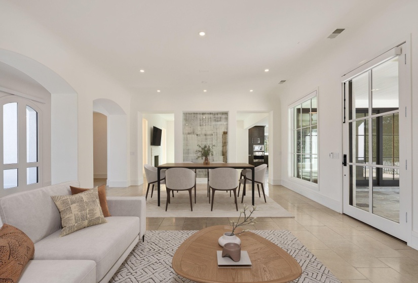Living room with recessed lighting, arched walkways, and light tile patterned floors