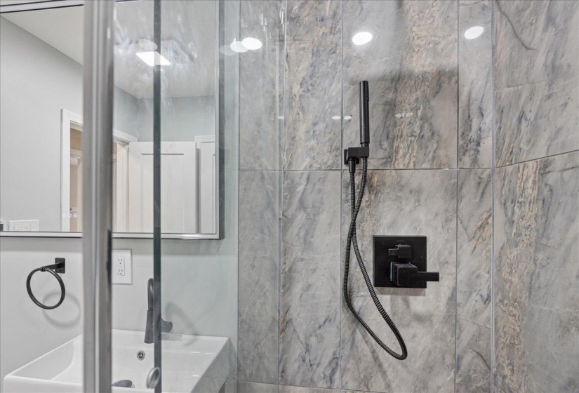 Full bathroom with a marble finish shower
