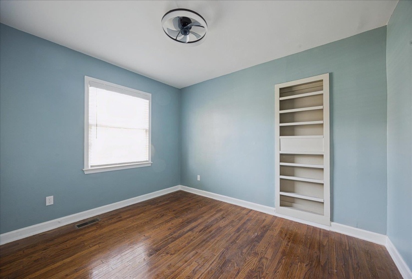 Spare room with dark wood-style flooring and ceiling fan