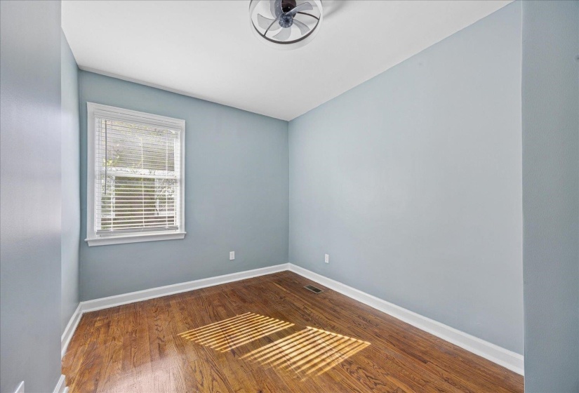 Empty room featuring baseboards and dark wood-type flooring