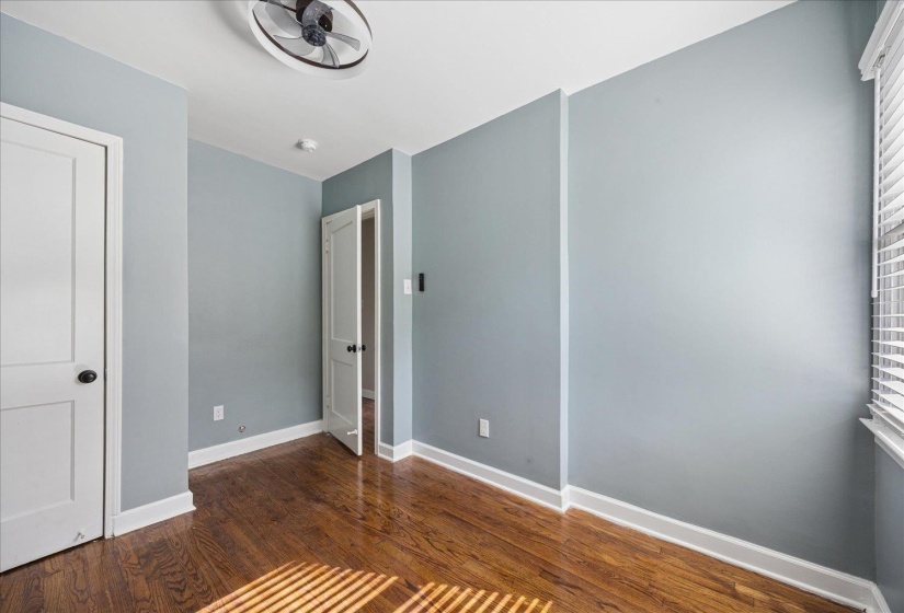Unfurnished bedroom featuring dark wood-style flooring and baseboards